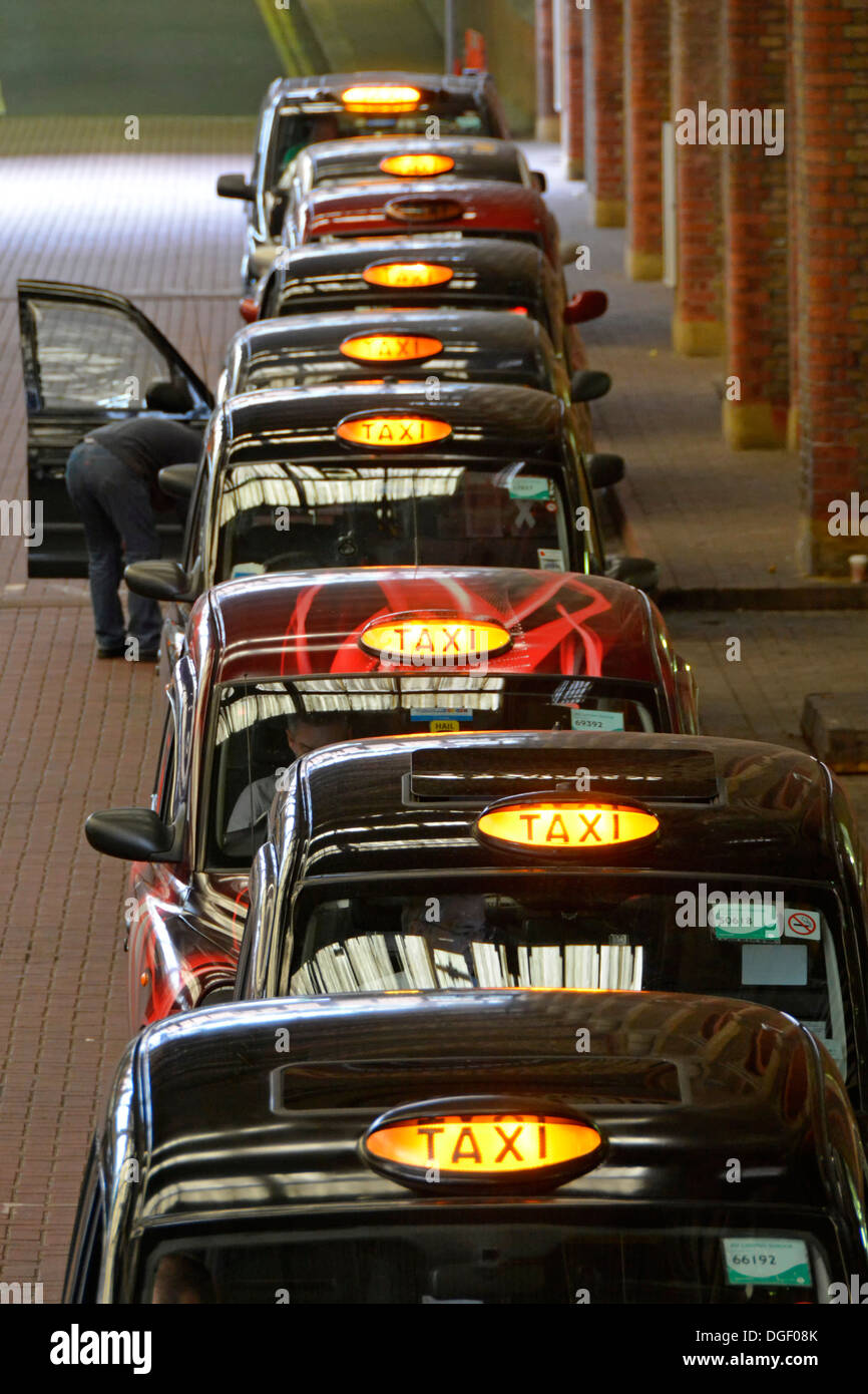Blick aus der Vogelperspektive auf die Warteschlange mit schwarzem Londoner Taxi im Bahnhof Liverpool Street, die auf Kunden warten, England Großbritannien Stockfoto