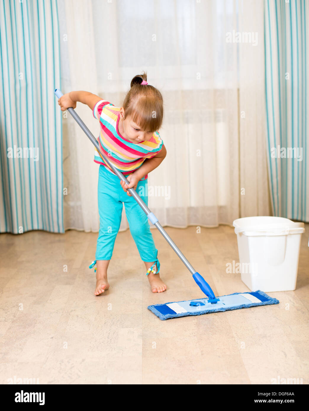 Kind Mädchen tun ihr Zimmer Reinigung Zimmer mit Mopp Stockfoto