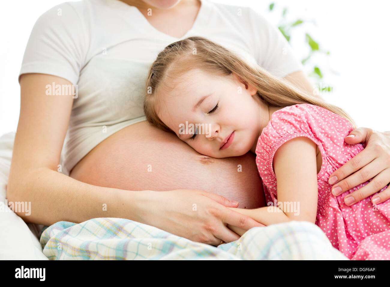 Kind Mädchen hören Bauch der schwangeren Mutter Stockfoto