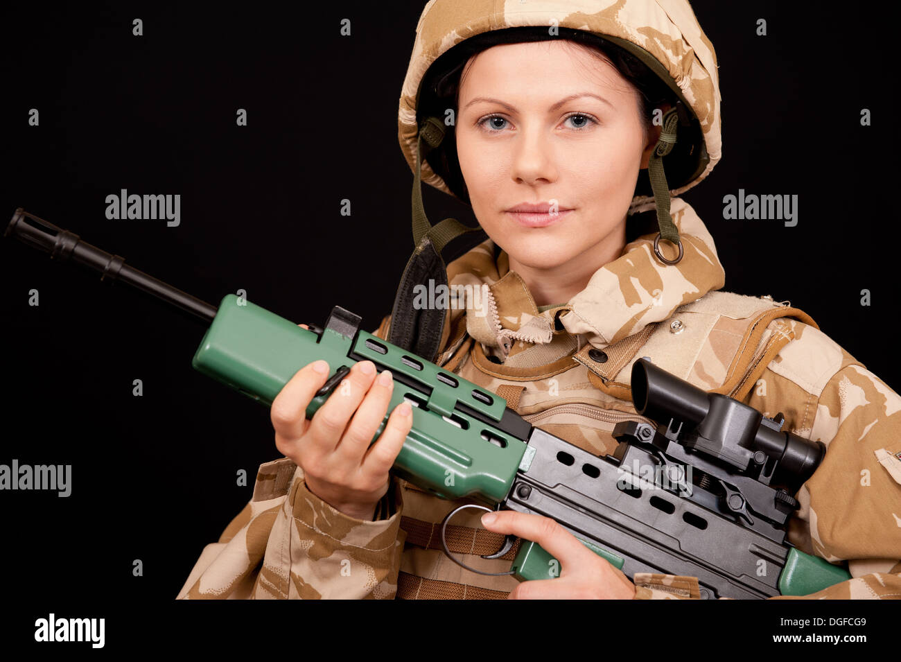 Junge weibliche Soldat hält eine SA80 Gewehr und britische militärische Wüste Tarnung-Uniform tragen. Stockfoto