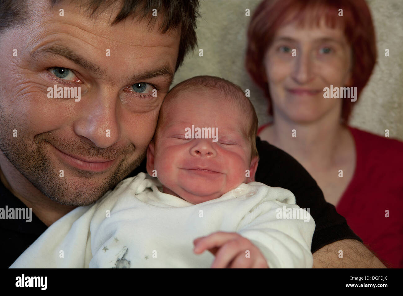 Familienporträt, stolzer Vater hält seinen neugeborenen Jungen Mutter hinten, Deutschland Stockfoto