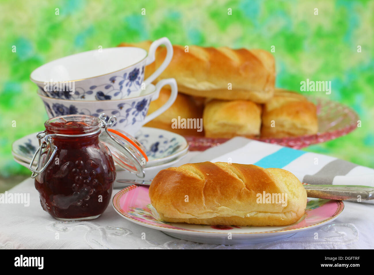 Teatime mit süßer Butter-Brötchen, Erdbeer-Marmelade und Tee Stockfoto