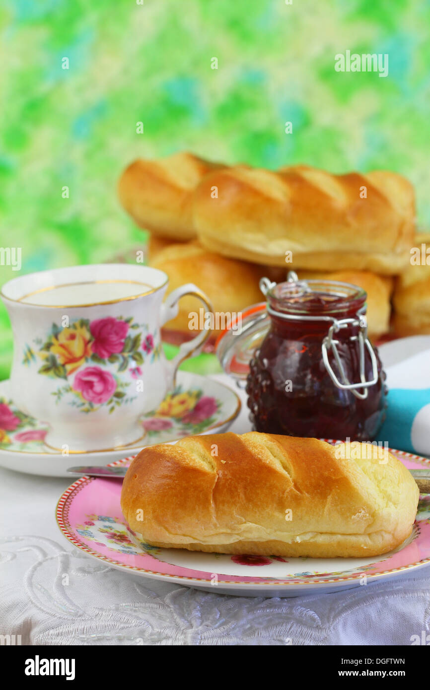 Teatime mit süßer Butter-Brötchen, Erdbeer-Marmelade und Tee Stockfoto