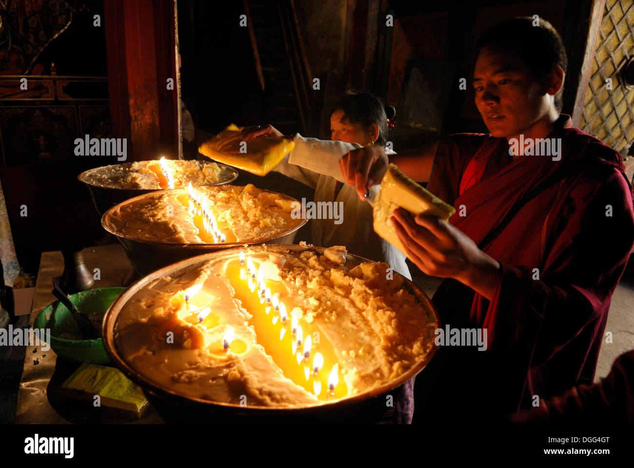Pilger und tibetische Mönche Nachfüllen der Messing Bogen mit Yak-Butter, Samye Kloster, Tibet, China, Asien Stockfoto