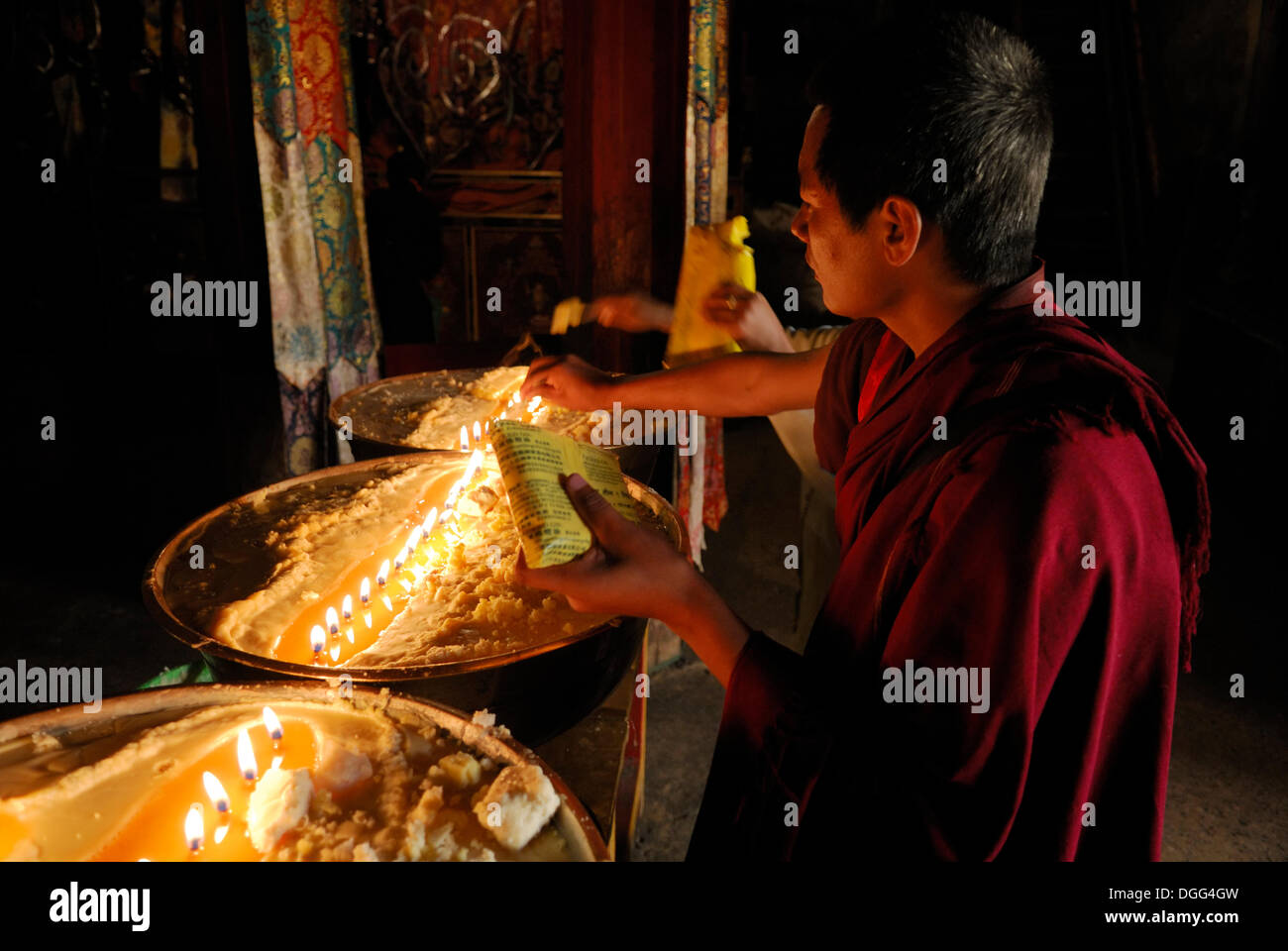 Pilger und tibetische Mönche Nachfüllen der Messing Bogen mit Yak-Butter, Samye Kloster, Tibet, China, Asien Stockfoto