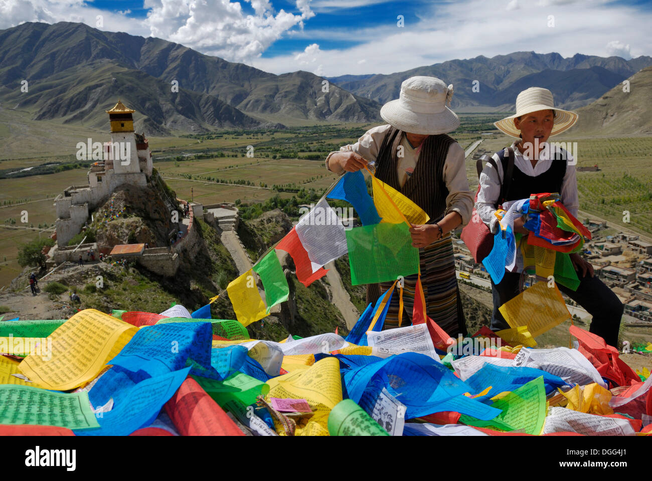 Tibetische Frauen mit Gebetsfahnen, Blick auf Burg Yumbulagang und Yarlung-Tal, Tsetang, Tibet, China, Asien Stockfoto