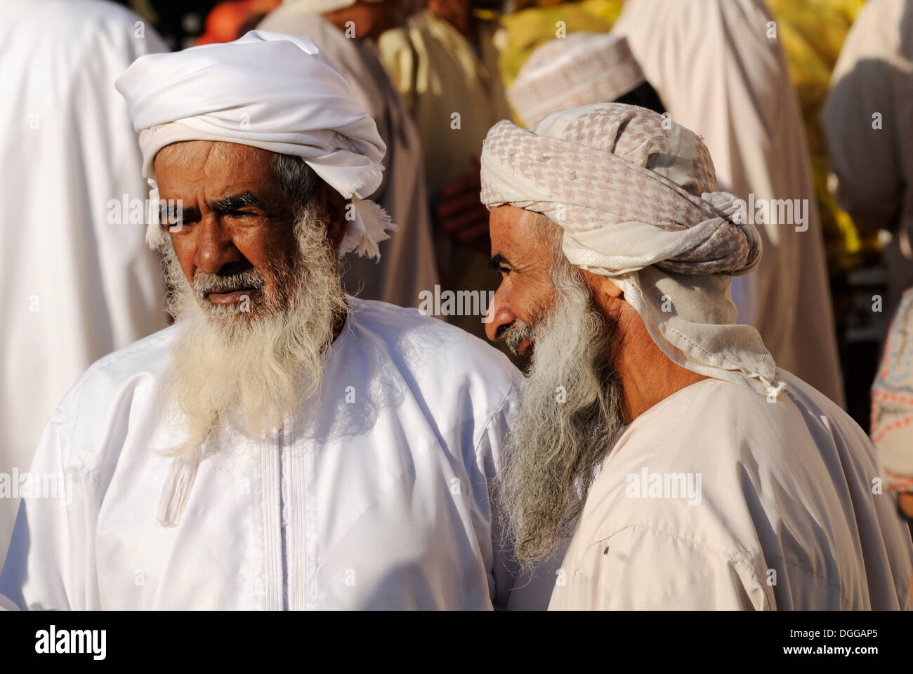 Omanische Männer in Tracht, Vieh oder Tiermarkt in Nizwa, Hajar al-Gharbi-Gebirge, Al Dakhliyah region Stockfoto