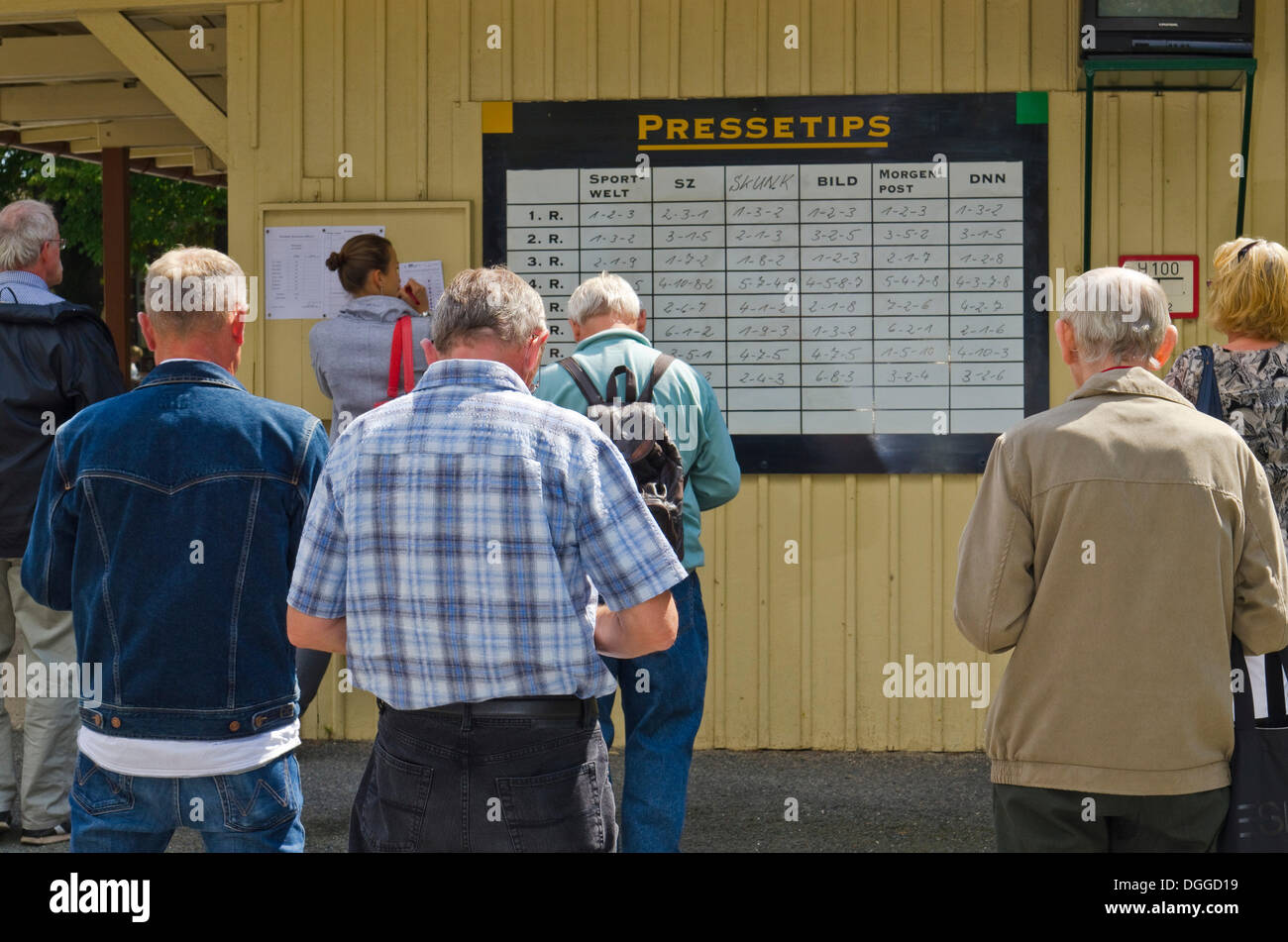 Menschen stehen vor Board mit der Wett-Tipps kurz vor einem Pferderennen, Dresden, Sachsen Stockfoto