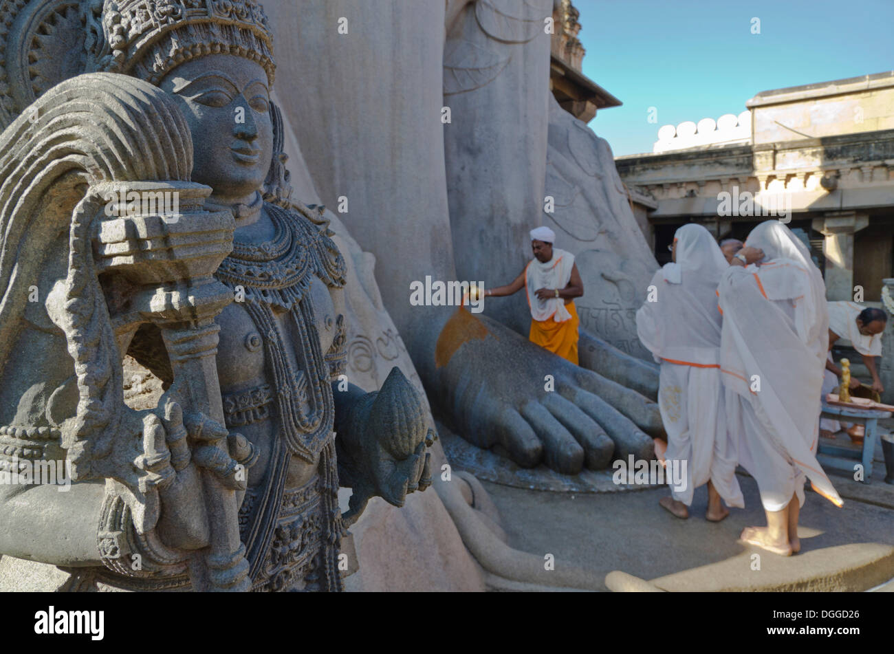 Jain Pilger tun eine spezielle Pooja vor der riesigen Statue, die Segnungen des Bahubali durch die lokalen Priester empfangen Stockfoto