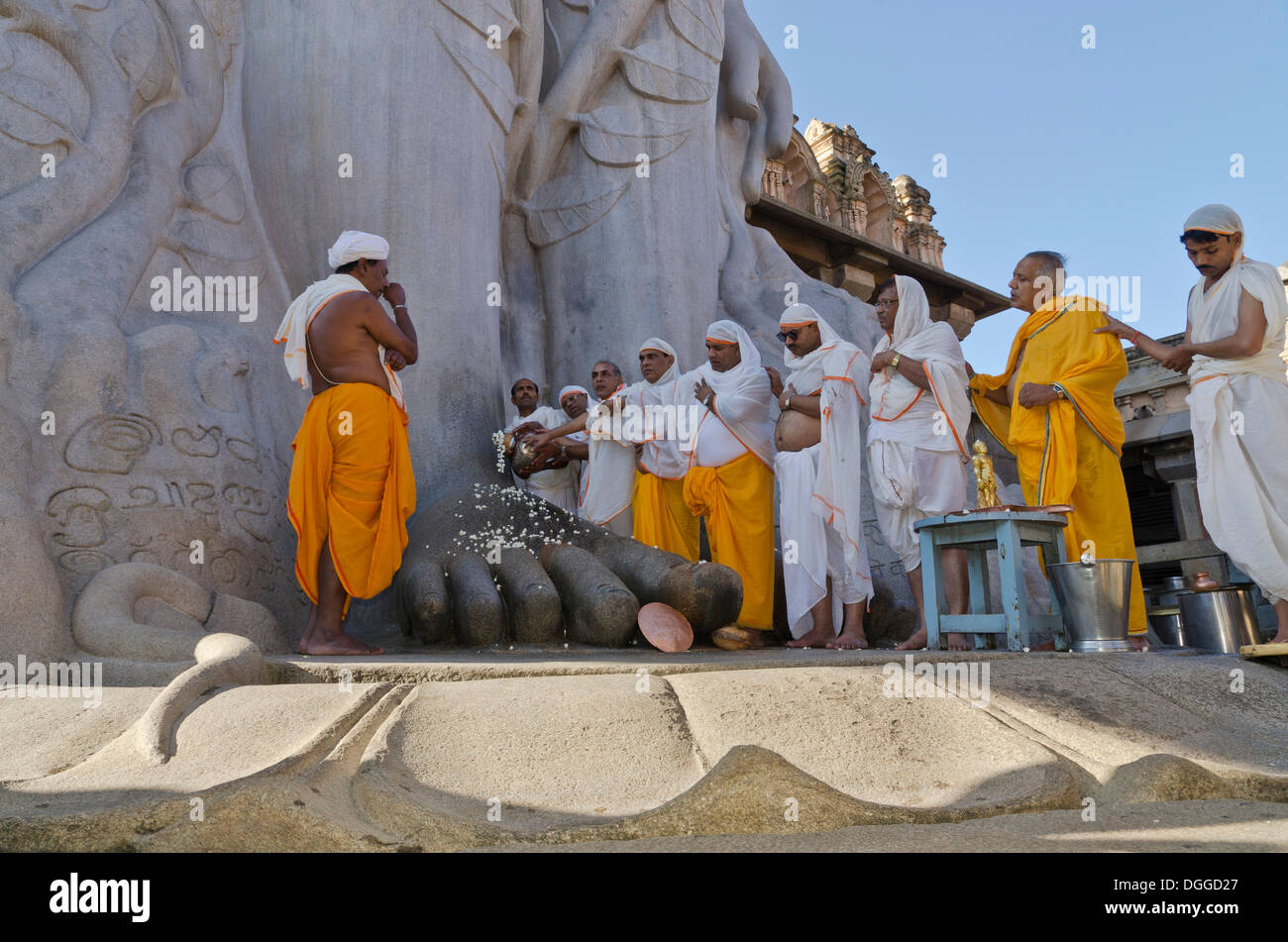 Jain Pilger tun eine spezielle Pooja vor der riesigen Statue, die Segnungen des Bahubali durch die lokalen Priester empfangen Stockfoto