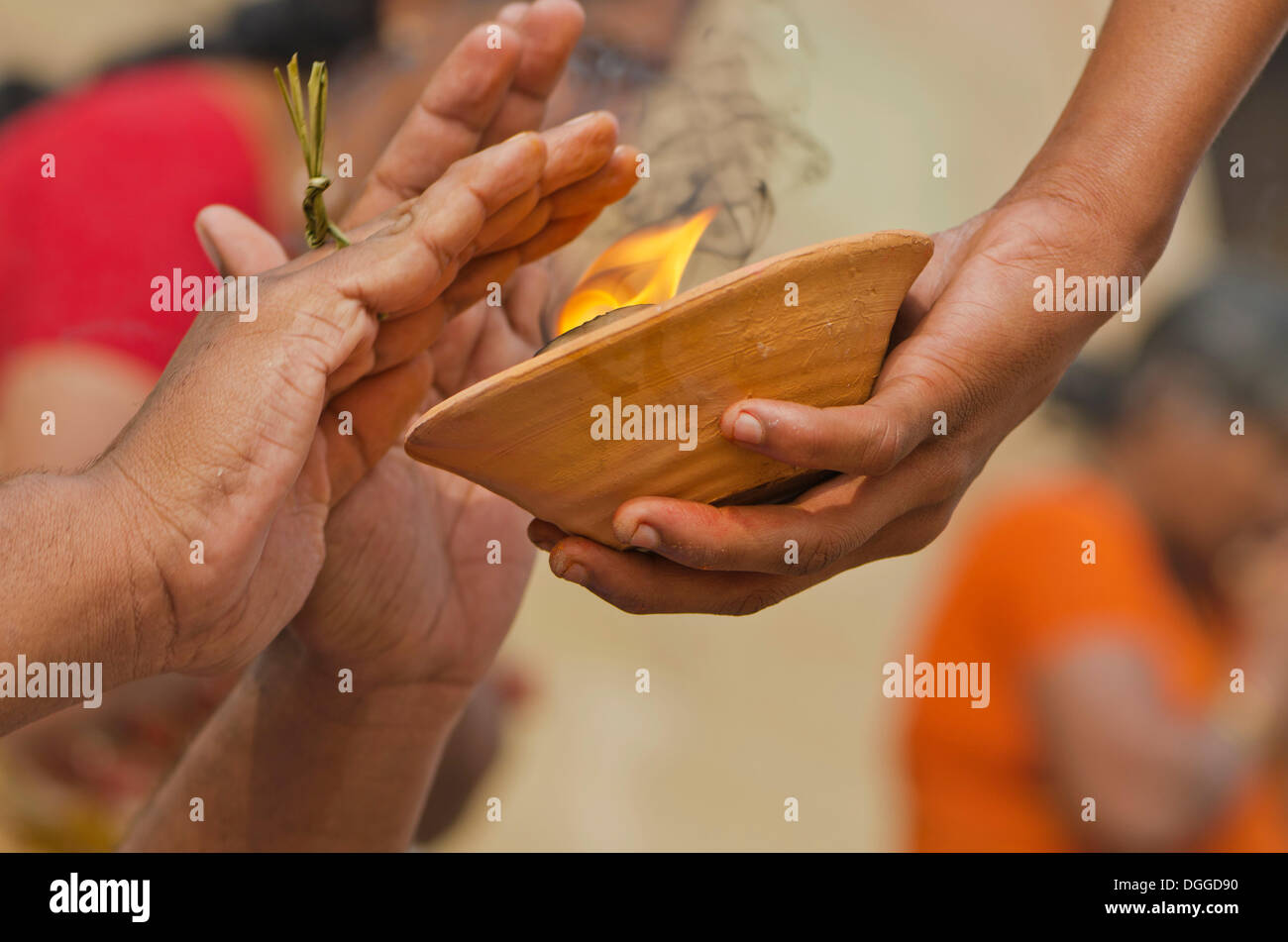 Hände über Feuer als Teil des Rituals zu beten Abschied für die Seele einer verstorbenen Person an den Ghats von Varanasi, Indien, Asien Stockfoto