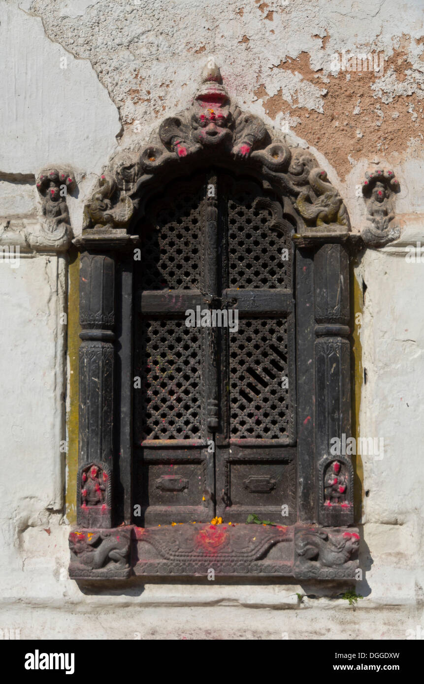 Verziert geschnitzten Holzfenster einen kleinen Schrein in den Hügeln oberhalb von Pashupatinath Tempel, Kathmandu, Kathmandu Bezirk Stockfoto