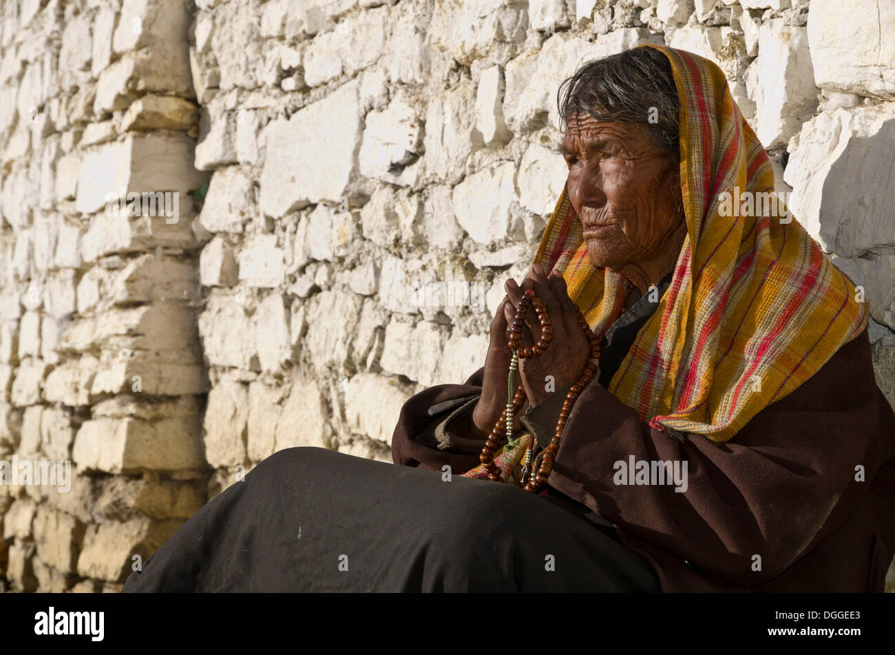 Alte Frau vor einer Mauer, Muktinath, beten senken Mustang, Nepal Stockfoto