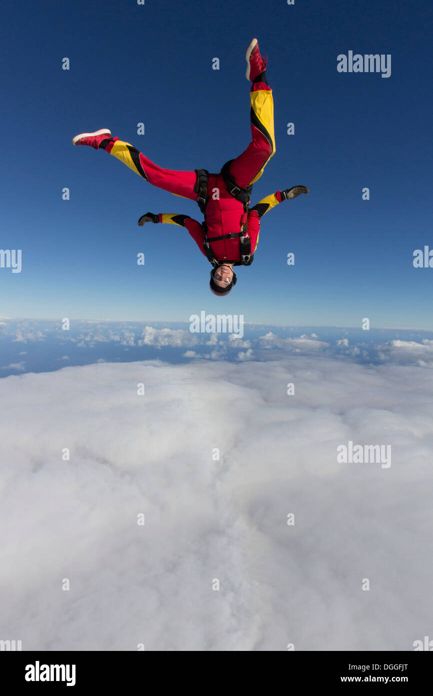 Weibliche Fallschirmspringer freien Fall auf den Kopf gestellt Stockfoto