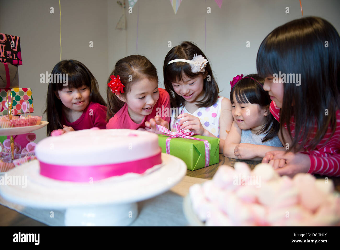 Mädchen Auspacken Geburtstagsgeschenk auf party Stockfoto