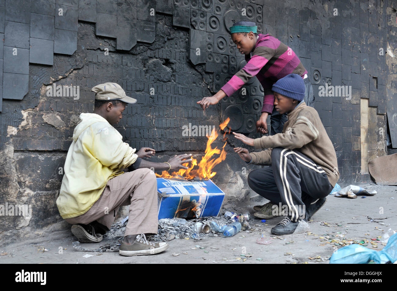 Straßenkinder, wärmten sich um ein Feuer in den frühen Morgenstunden, Stadtteil Hillbrow, Johannesburg, Südafrika, Afrika Stockfoto