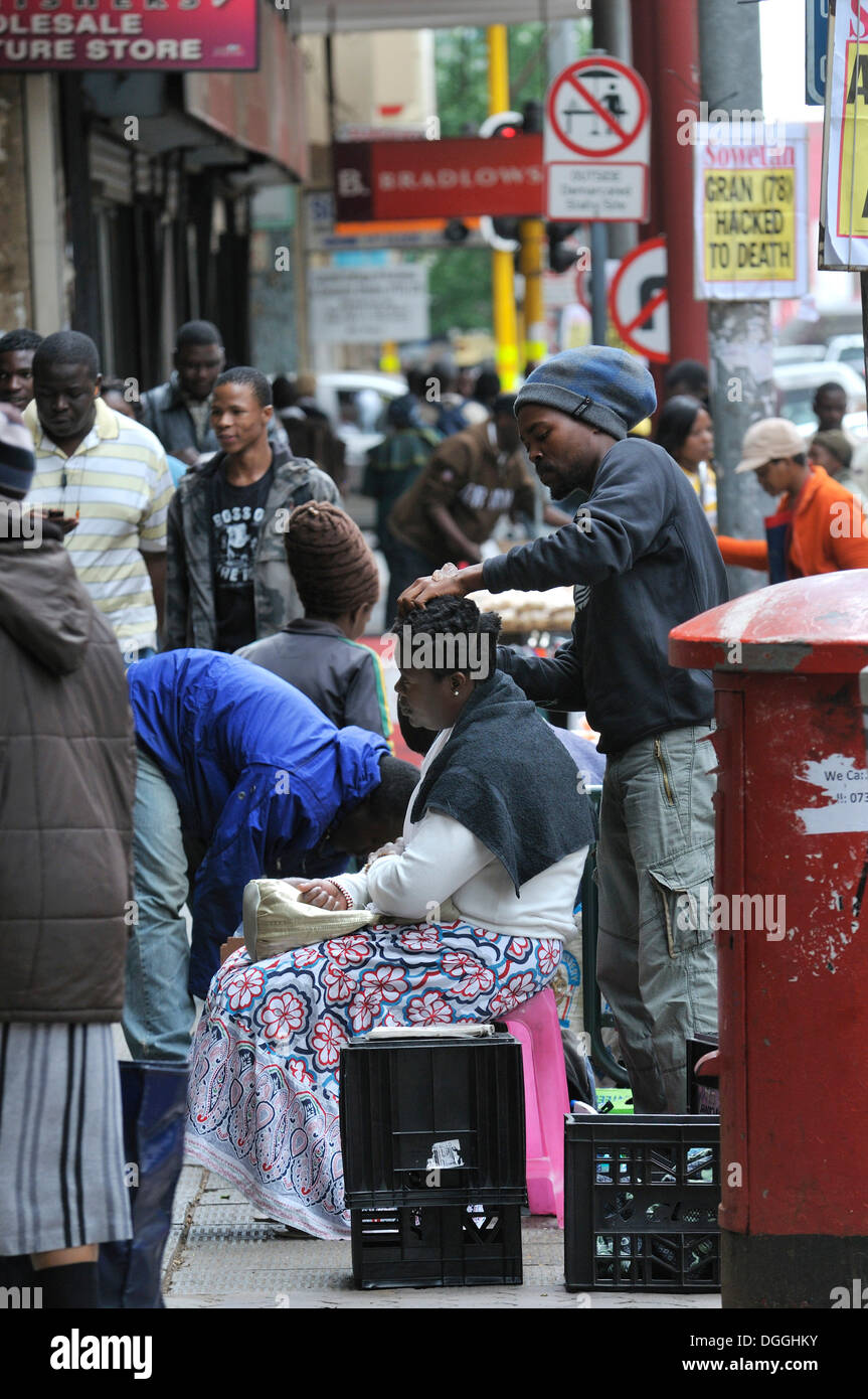 Informellen Sektor, ein Friseur auf der Straße im Zentrum von Johannesburg, Südafrika, Afrika Stockfoto
