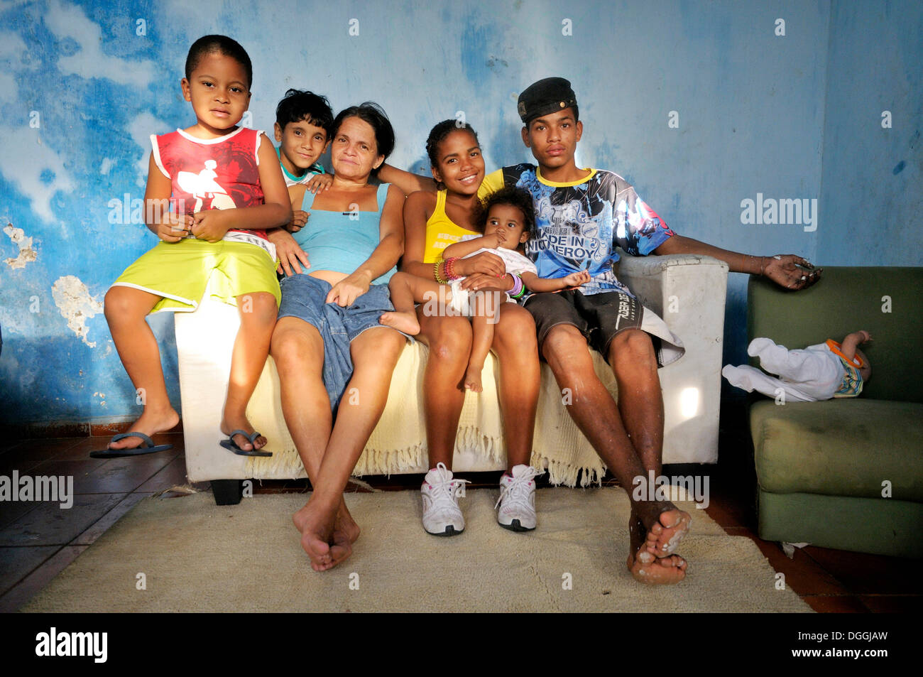 Alleinerziehende Mutter und ihre Kinder und Enkel sitzen auf einem Sofa, Favela Morro da Formiga Slum, Tijuca district Stockfoto