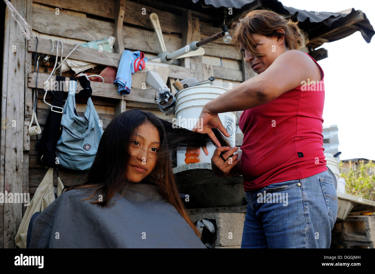 Mutter macht ihre Tochter Haare, 10 Jahre altes Mädchen in einem armen Viertel von Cancun, Halbinsel Yucatan, Quintana Roo, Mexiko Stockfoto