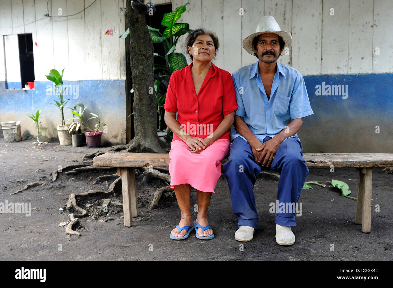 Paar, 58 und 59, sitzen auf einer Bank vor einem Haus, La Sabaneta, Departamento Masaya, Nicaragua Stockfoto