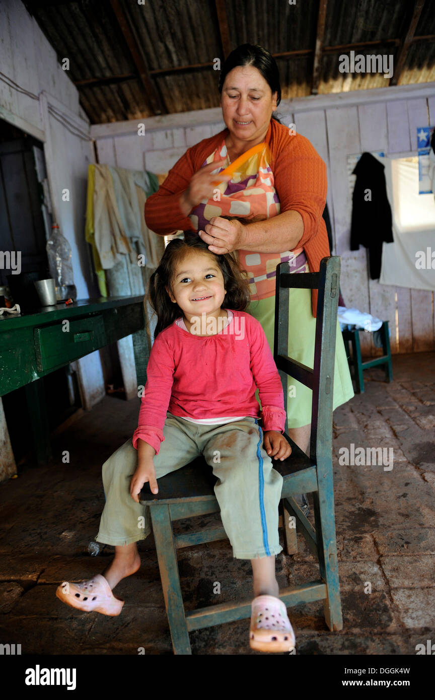 Großmutter, 74, kämmen das Haar ihrer Enkelin, 3, Pastoreo, Caaguazu Abteilung, Paraguay Stockfoto