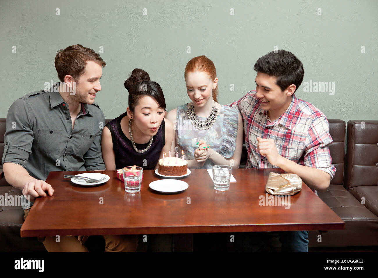 Vier Freunde feiern Geburtstag im restaurant Stockfoto