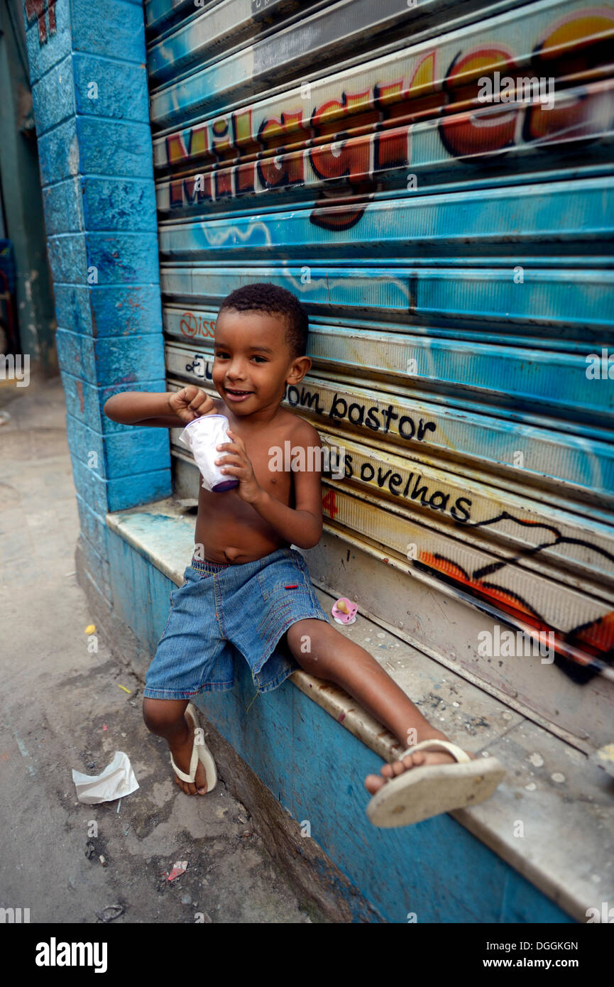 Junge Essen aus einer Wanne mit Eis in einem Slum oder Favela, Jacarezinho Favela, Rio De Janeiro, Bundesstaat Rio De Janeiro, Brasilien Stockfoto