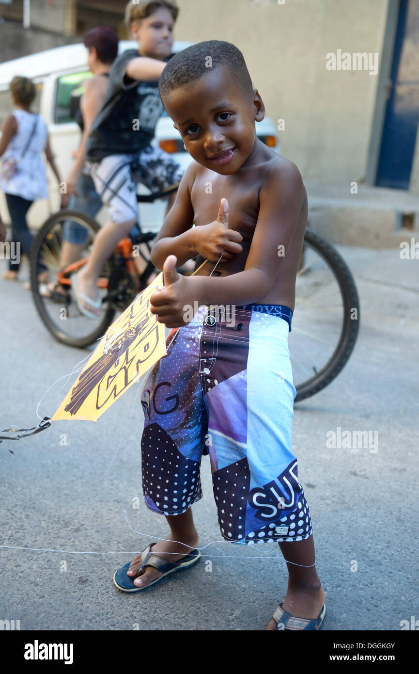 Kleiner Junge hält einen Drachen in einem Slum oder Favela, Jacarezinho Favela, Rio De Janeiro, Bundesstaat Rio De Janeiro, Brasilien Stockfoto