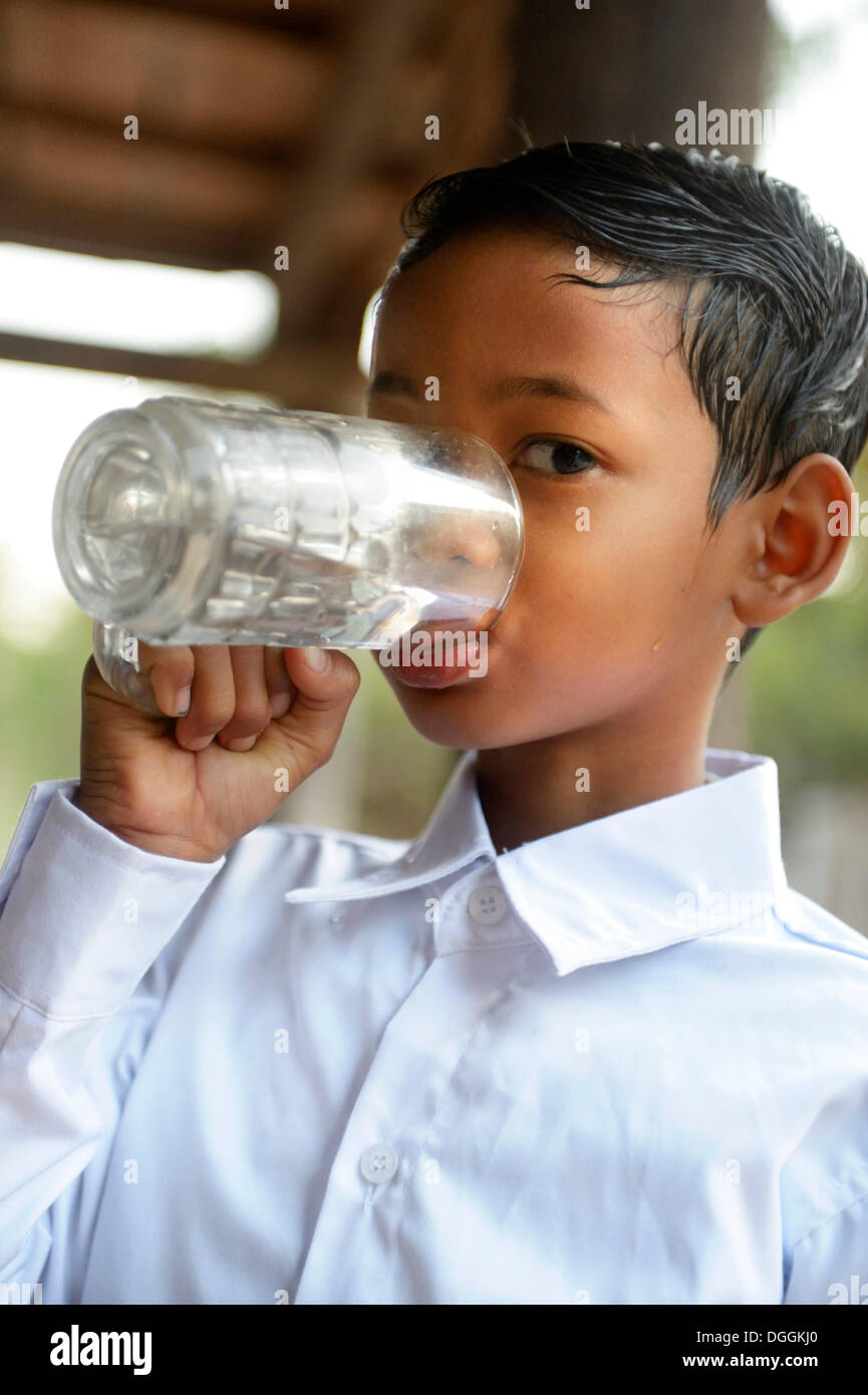 Junge Trinkwasser aus einem Glas, Lompong Gemeinde, versaut District, originellen Provinz, Kambodscha Stockfoto
