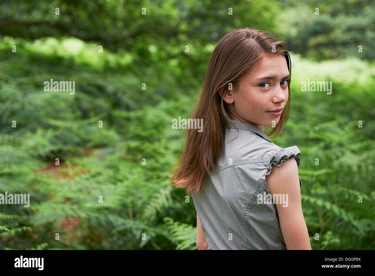 Teenager-Mädchen auf der Suche über die Schulter im Wald Stockfoto
