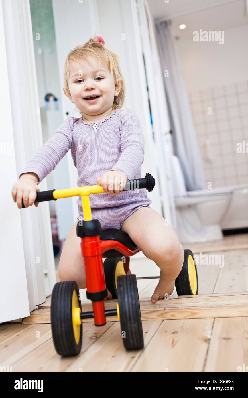 Kleinkind Mädchen spielen auf Dreirad Stockfoto