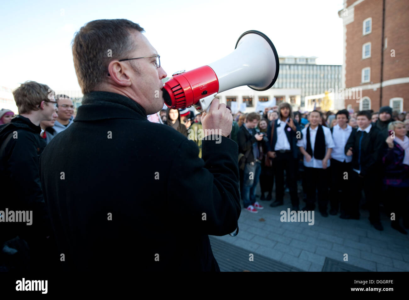 Mann mit Megaphon im Gespräch mit Massen von Menschen Stockfoto