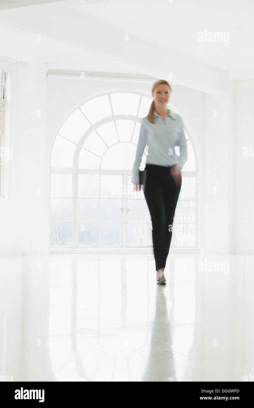 Geschäftsfrau, die zu Fuß in spärlichen weißen Raum Stockfoto