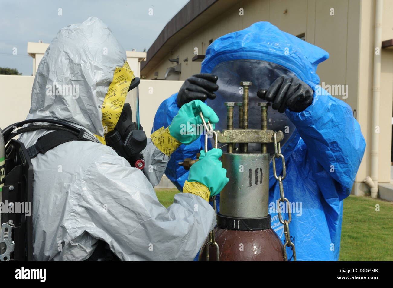 Flieger aus dem 374th Bauingenieur-Geschwader-Feuerwehr und Bereitschaft und Emergency Management Flug befestigen Sie einen Chlor-Zylinder A-Kit eine simulierte undichte Behälter auf der Yokota Air Base, Japan, am 10. Oktober 2013. Die 374th Airlift Wing durchgeführt lesen Stockfoto