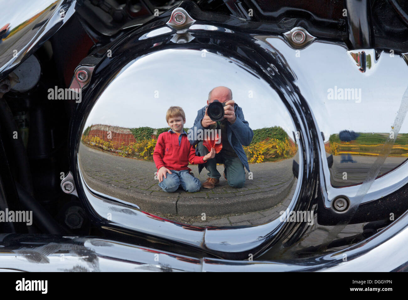 Spiegelbild eines jungen und eines Mannes, Motorrad Stockfoto