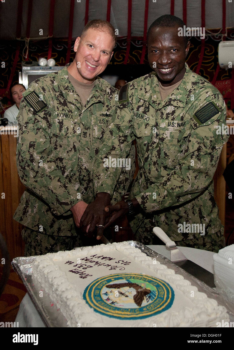 Petty Officer Class Kevin Konkol, US Marine Forces Central Command senior verpflichtete Führung, links, und Petty Officer 3rd Class Wendyaode Garango, NAVCENT Logistik-Spezialist, schneiden Kuchen als das älteste und jüngste Navy, die Marine 238. b teilnehmende Mitglieder Stockfoto