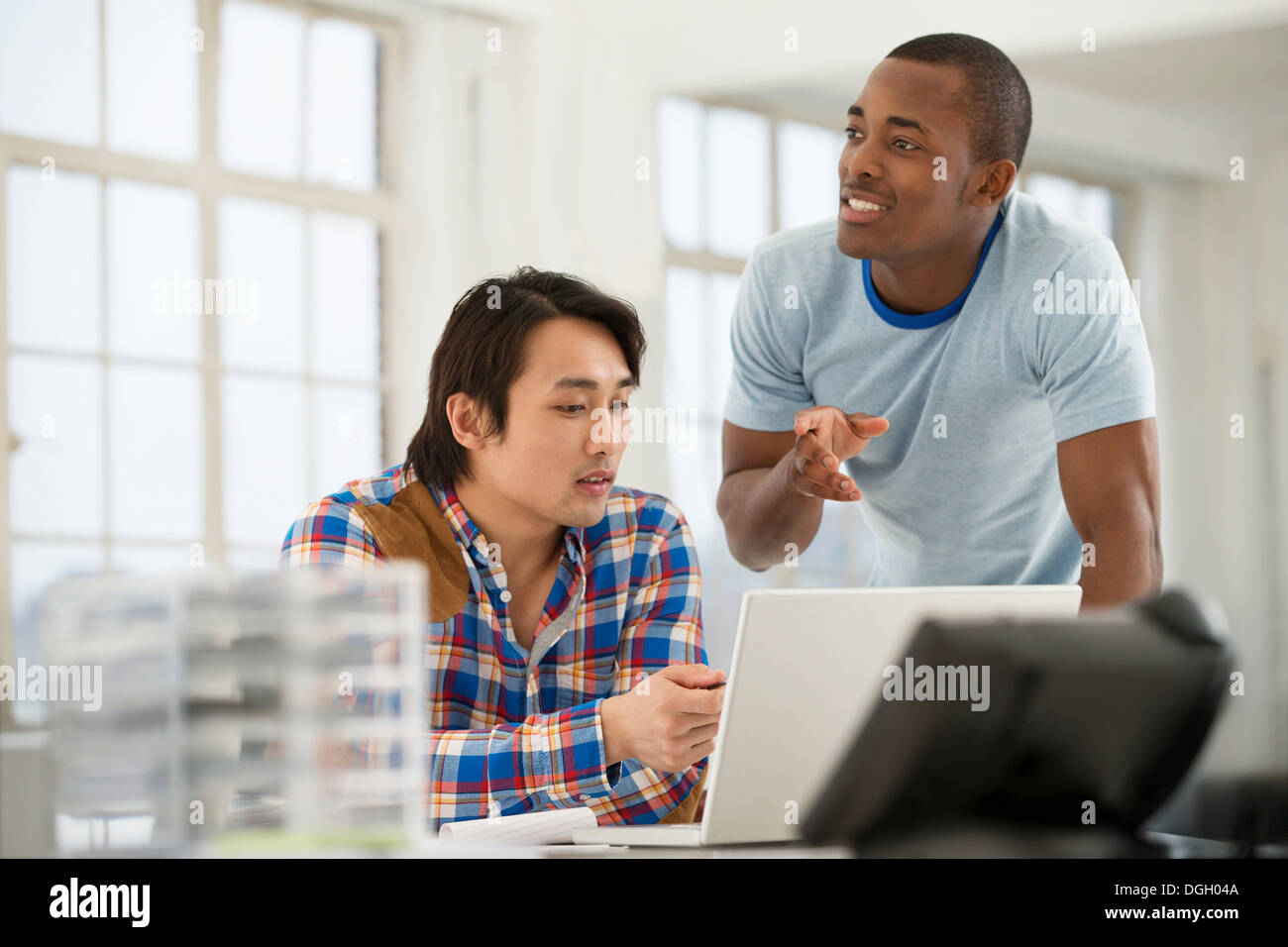 Zwei männliche Kollegen, die mit laptop Stockfoto