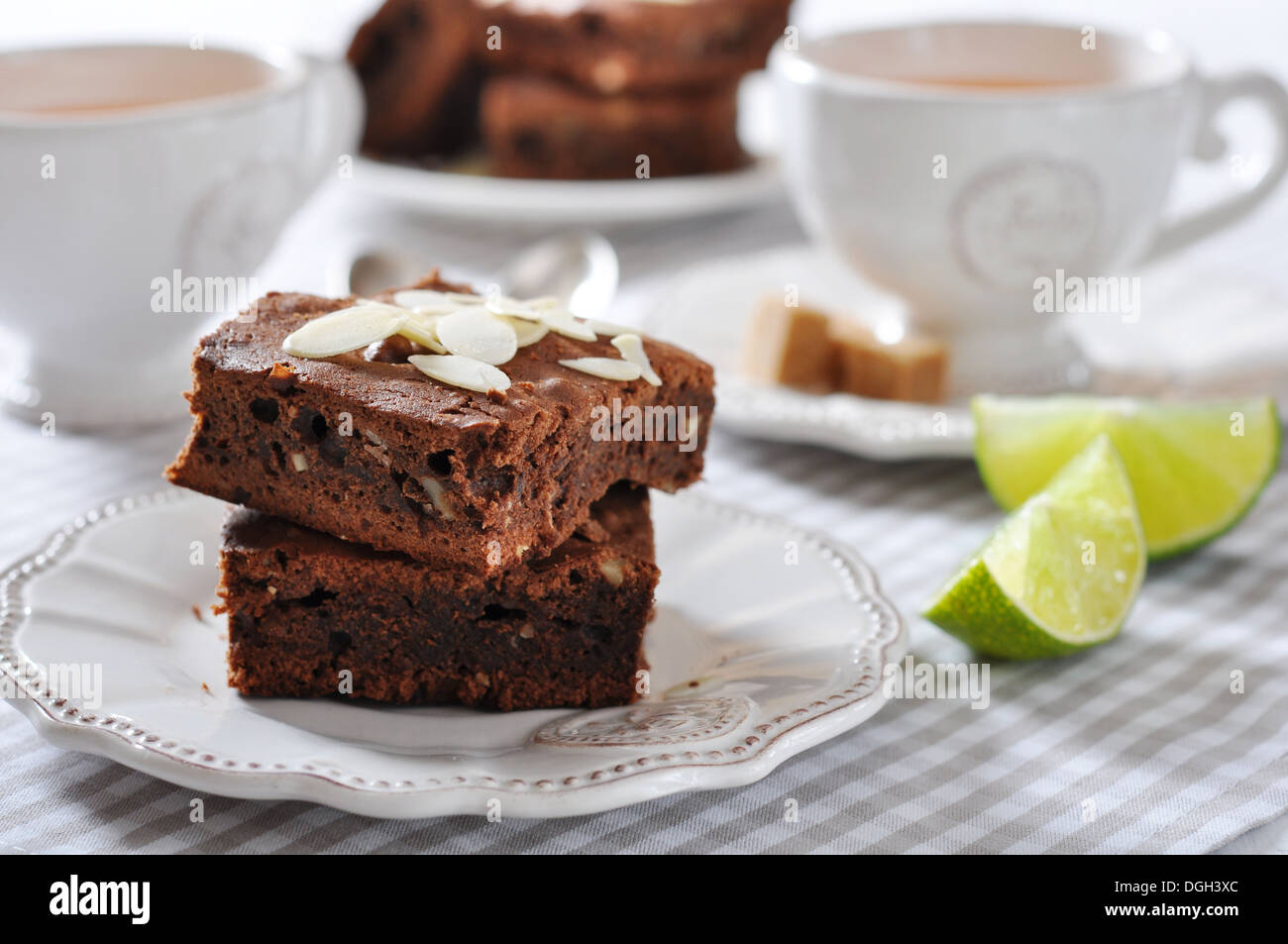 Brownie-Kuchen mit Mandelblättchen und Tasse Tee closeup Stockfoto