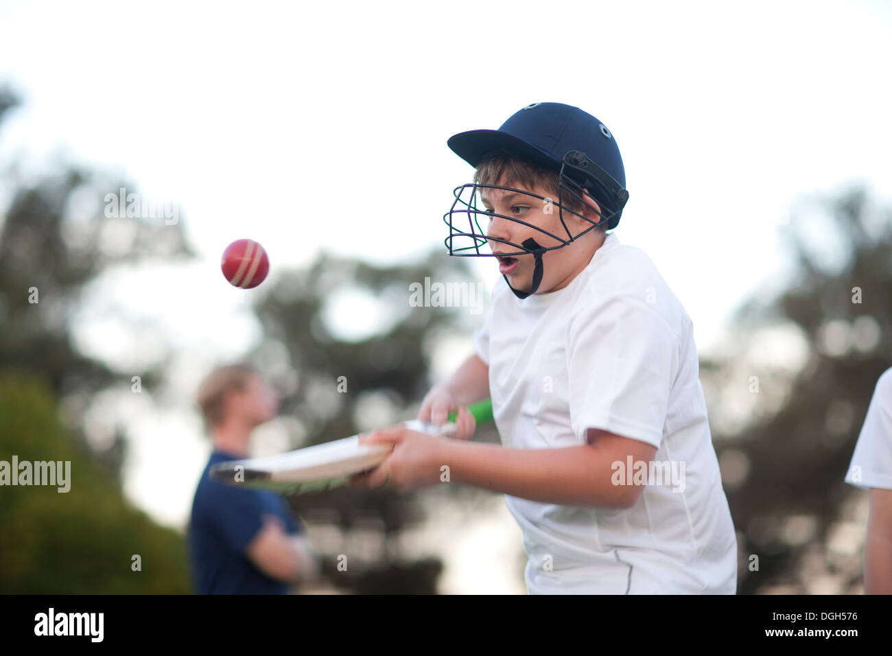 Junge üben schlagen Cricketball mit Fledermaus Stockfoto