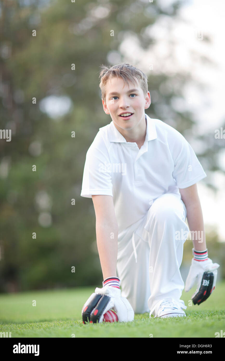 Junge kniend auf Cricket-Platz Stockfoto