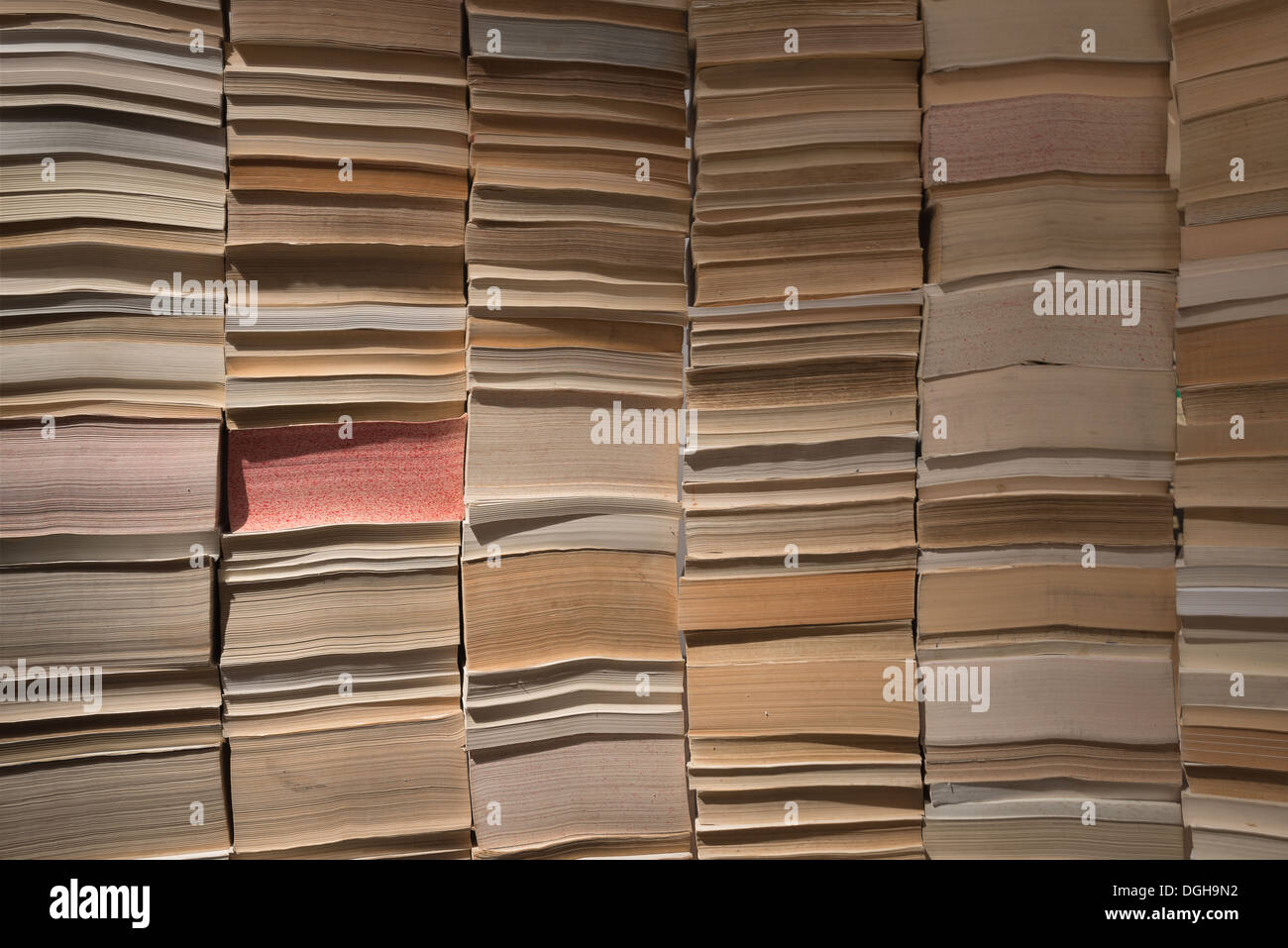 Massen von alten Büchern aus Papier gestapelt in Reihen nebeneinander angeordnet Stacheln Seiten erstellen einer Mauer-Grenze Stockfoto