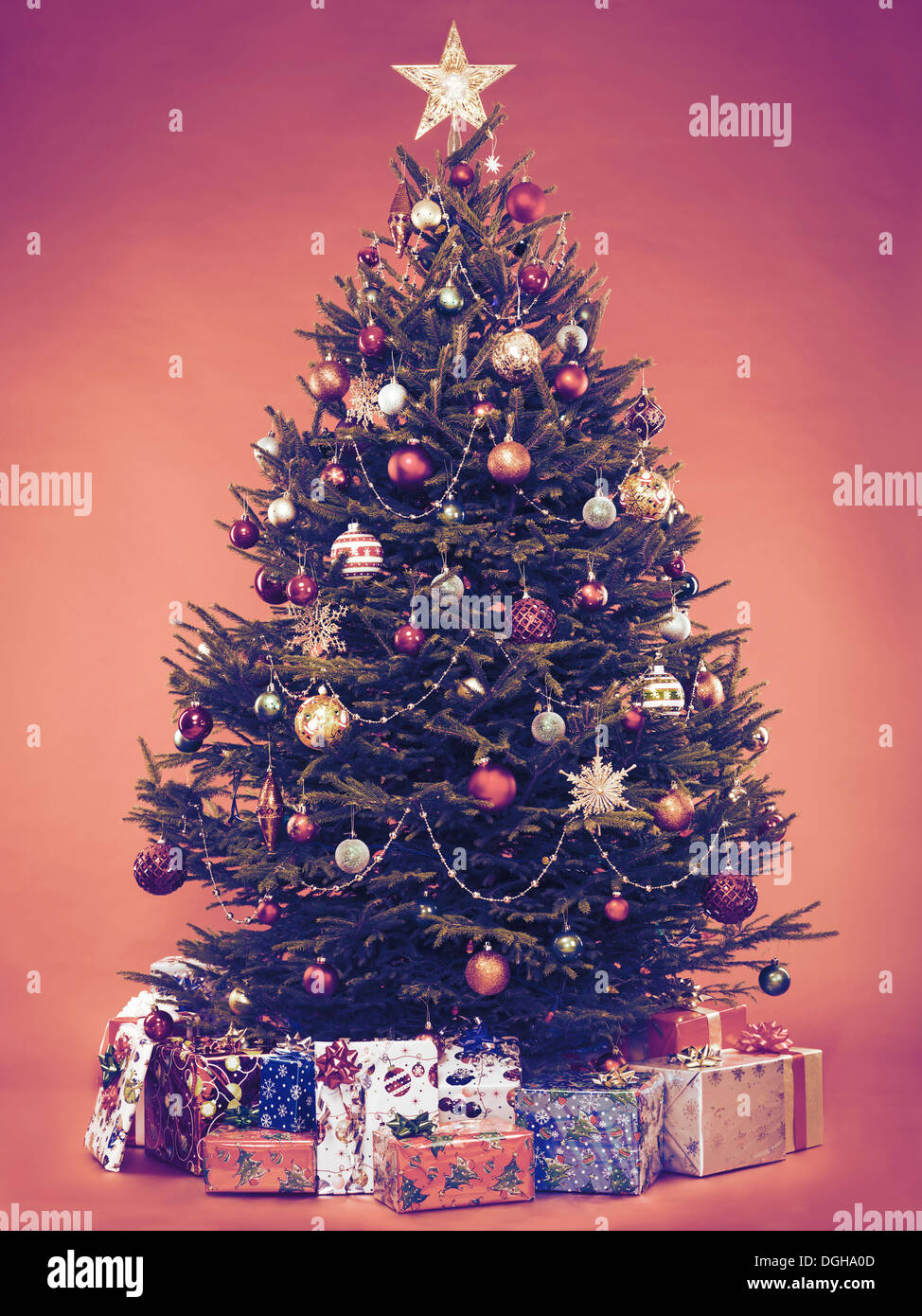 Schön dekorierte Vintage stilisierten Weihnachtsbaum mit verpackte Geschenke unter ihm. Auf braunem Hintergrund isoliert. Stockfoto