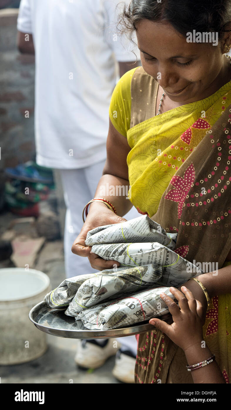 Indische Dorf Frau mit Geschenken von Lebensmitteln von Sri Sathya Sai Baba Organisation gegeben. Andhra Pradesh, Indien Stockfoto