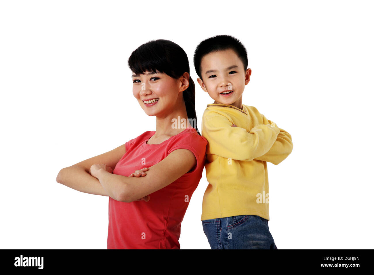 Ostasiatische Mutter und Sohn stehen Rücken an Rücken, Falten die Hände, lächelt und schaut in die Kamera Stockfoto