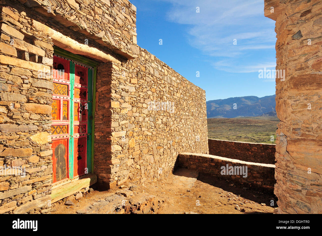 Natursteinmauern, Haus mit einem bunten Holztür, Tizourgane, Souss-Massa-Draâ, Antiatlas, Marokko Stockfoto