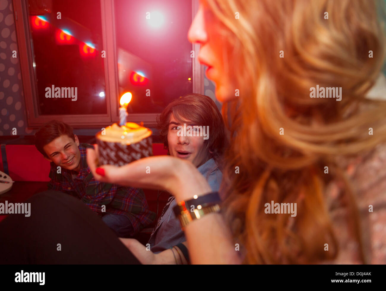 Junges Mädchen bläst Kerzen auf Geburtstagskuchen Stockfoto
