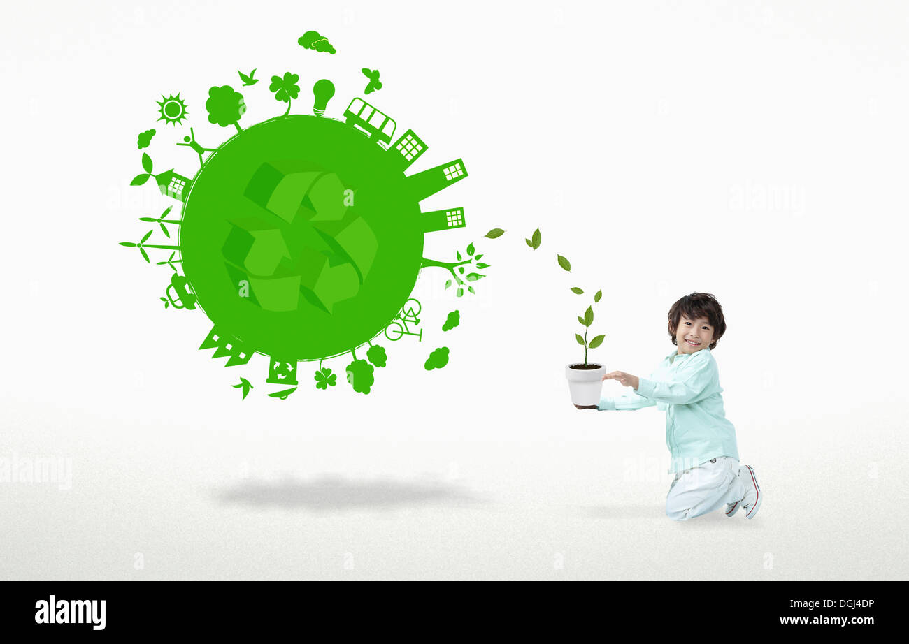 ein junge neben eine grüne Kugel mit einem recycling-Symbol Stockfoto