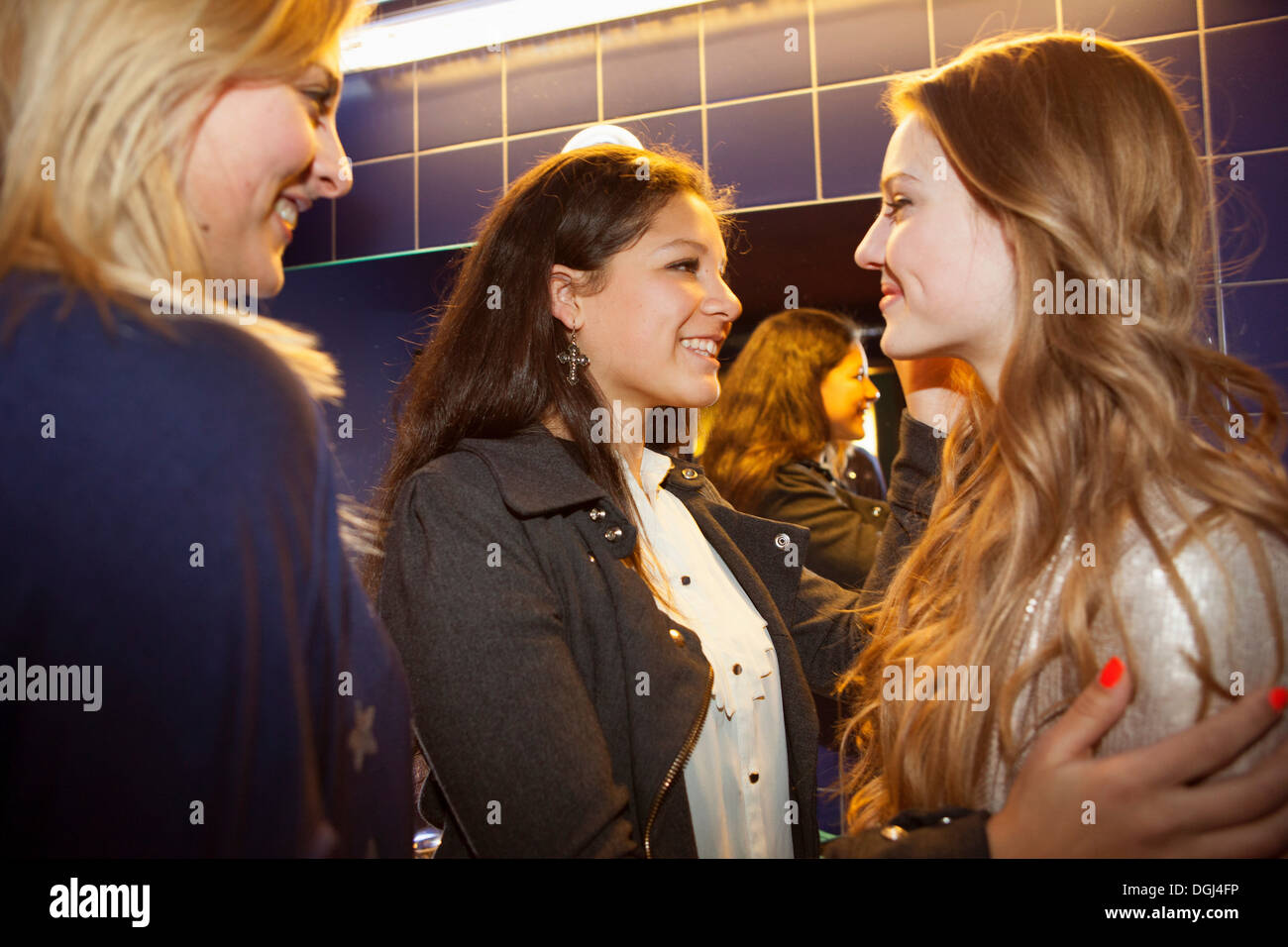 Drei Mädchen im Teenageralter im Chat und lächelnd in Toiletten Stockfoto