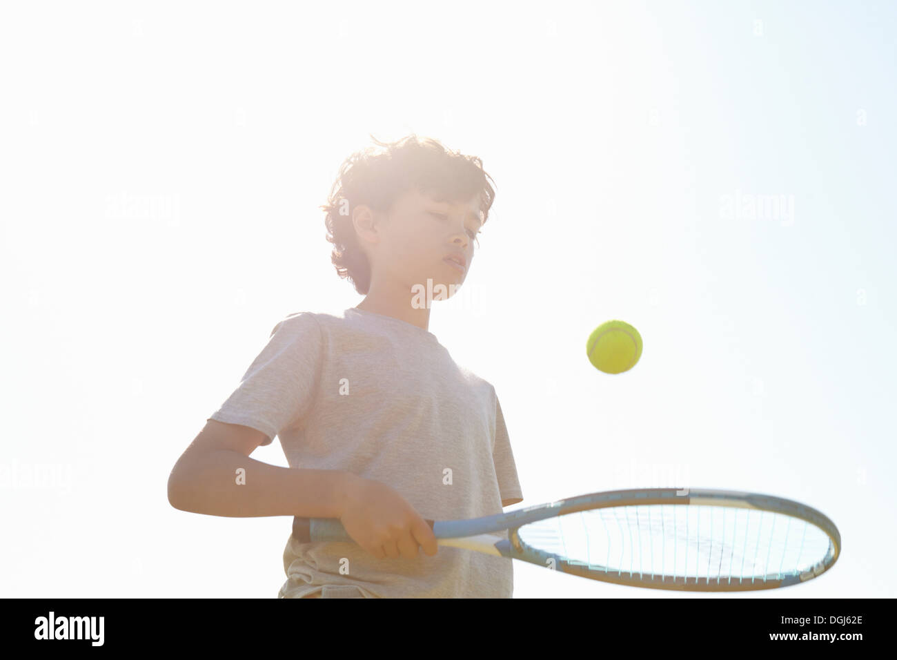 Junge springenden Ball auf Tennisschläger Stockfoto