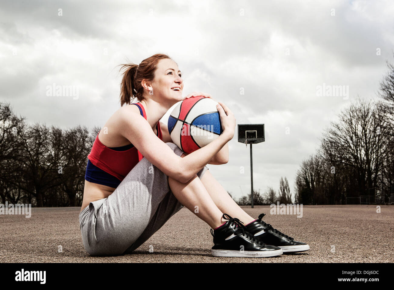 Frau umarmt Korbball bis zum Kinn Stockfoto